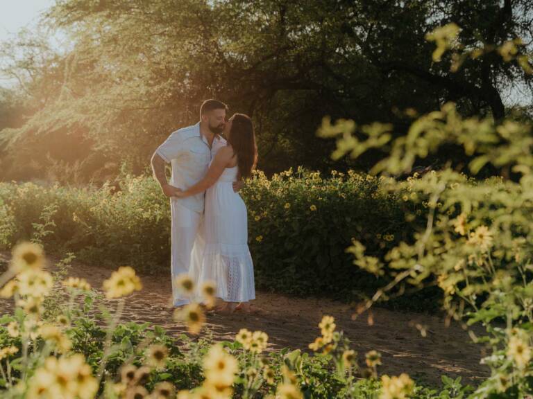 Romantic Maui engagement photos with yellow spring wildflowers near the beach