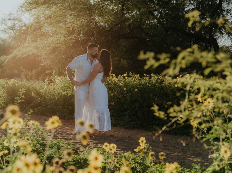 Romantic Maui engagement photos with yellow spring wildflowers near the beach